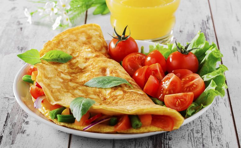 Receita Fitness Omelete, Deliciosa omelete dourada, recheada e servida quente, pronta para servir.